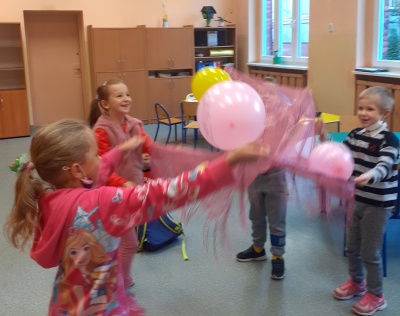 Dzieci odbijają chustą balony