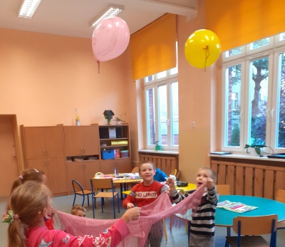 Dzieci odbijają chustą balony