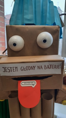 Robot z tektury z napisem "Jestem głodny na baterie"